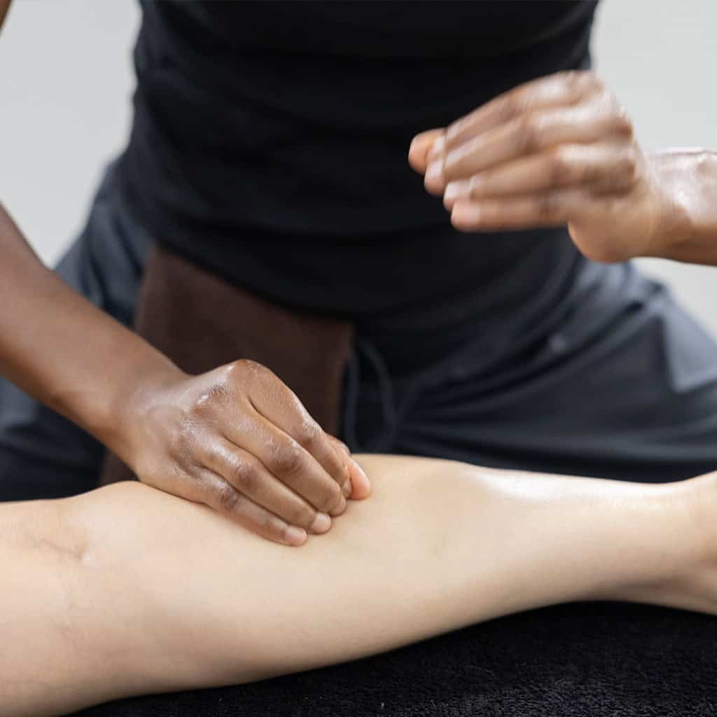 Ambre de vie faisant un massage balinais sur la jambe de sa cliente