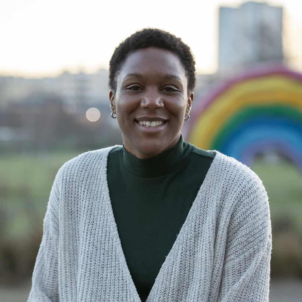 Ambre de vie souriante avec un arc-en-ciel gonflable dans le fond