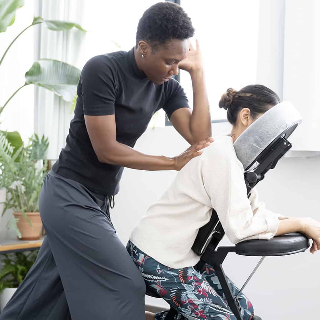 Ambre de vie faisant un massage du dos en entreprise à une cliente