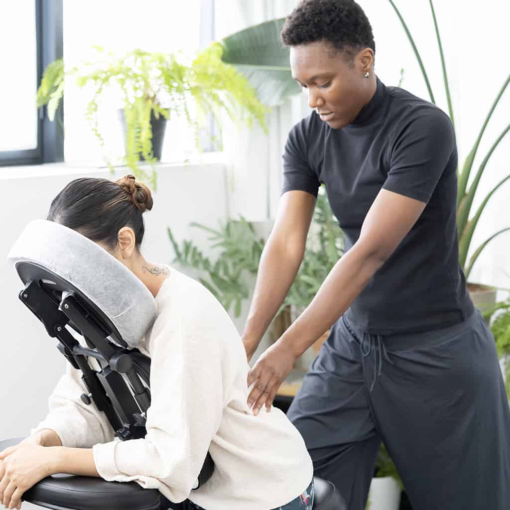 Ambre de vie faisant un massage du dos en entreprise à une cliente